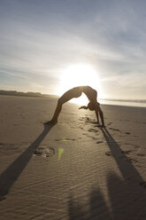 South Africa, Cape Town, silhouette of young woman in bridge position on the beach - ZEF005205