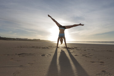 South Africa, Cape Town, silhouette of young woman doing handstand on the beach - ZEF005207