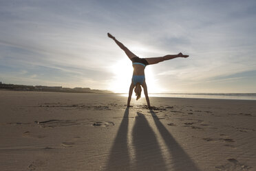 Südafrika, Kapstadt, Silhouette einer jungen Frau im Handstand am Strand - ZEF005207