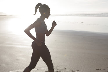 South Africa, Cape Town, silhouette of young woman jogging on the beach - ZEF005212