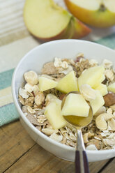 Bowl of granola and nuts with pieces of an apple - ASF005618