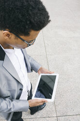 Junger Mann benutzt ein digitales Tablet im Freien - ABZF000059