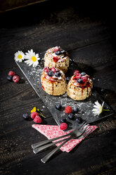 Filo pastry tartlets filled with vanilla ice cream and whipped cream garnished with blueberries and raspberries - MAEF010558