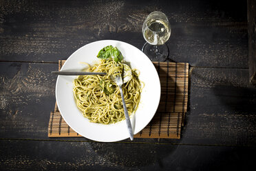 Plate of spaghetti with pesto Genovese and glass of white wine - MAEF010594