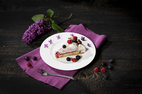 Stück Himbeer-Sahne-Torte garniert mit Heidelbeeren, lizenzfreies Stockfoto