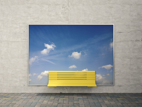 Gelbe Bank vor Werbetafel mit Himmel und Wolken, lizenzfreies Stockfoto