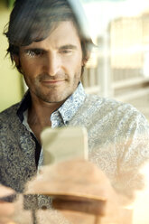 Porträt eines Mannes mit Smartphone - TOYF000978