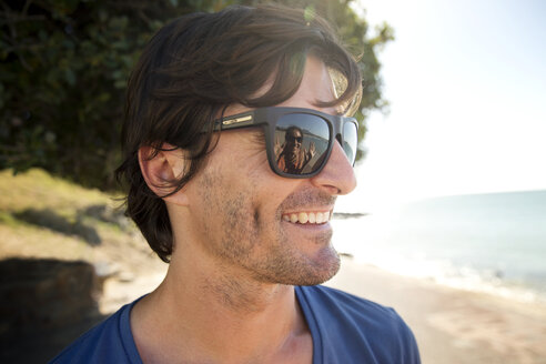 Südafrika, Porträt eines lächelnden Mannes mit Sonnenbrille - TOYF001034