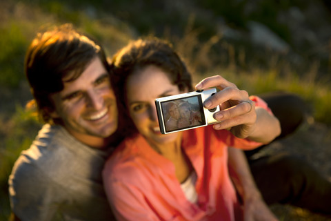 Südafrika, Paar macht ein Selfie in der Abenddämmerung, lizenzfreies Stockfoto