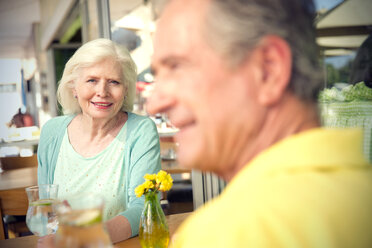 Portrait of happy senior woman sitting with her husband in a cafe - TOYF000995