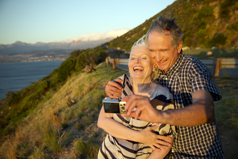 South Africa, happy senior couple taking a selfie by sunset stock photo