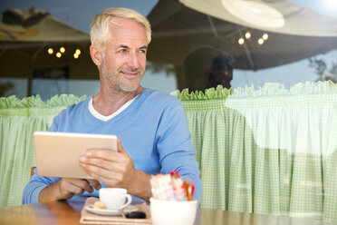 Porträt eines lächelnden Mannes mit digitalem Tablet - TOYF001021