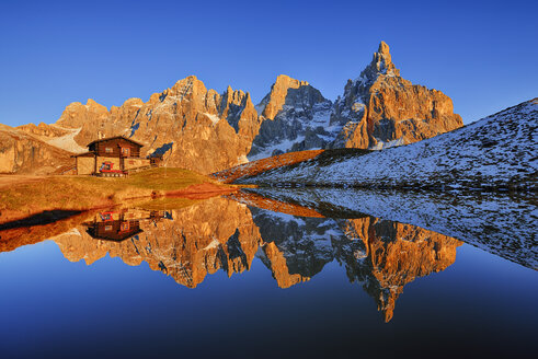 Italien, Dolomiten, Trentino, Pale di San Martino und Cimon della Pala mit Baita Segantini, die sich im kleinen See bei Sonnenuntergang spiegelt - RUEF001612