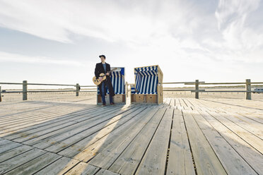 Deutschland, Sankt Peter-Ording, Jugendlicher mit Gitarre vor vermummtem Strandkorb stehend - MSF004569