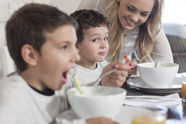 Junge mit Familie beim Mittagessen im Speisesaal, der gesundes Essen ablehnt - ZEF005380