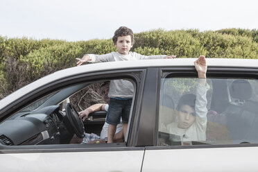 Junge schaut durch das Schiebedach eines Familienautos - ZEF005391