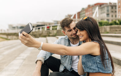 Spain, Gijon, young couple in love taking selfie with smartphone - MGOF000251