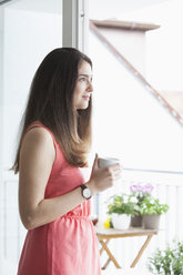 Junge Frau mit Kaffeetasse am Morgen - RBF002876