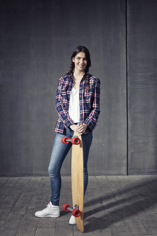 Junge Frau mit Longboard, lizenzfreies Stockfoto