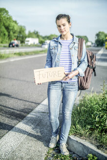 Deutschland, Porträt einer Anhalterin mit dem Schild 