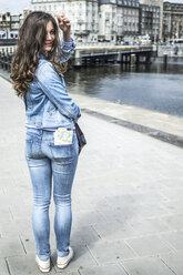 Netherlands, Amsterdam, female tourist with city map in her trouser pocket - RIBF000071