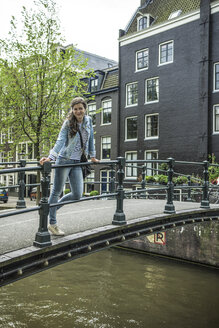 Niederlande, Amsterdam, Touristin auf Fußgängerbrücke stehend - RIBF000083