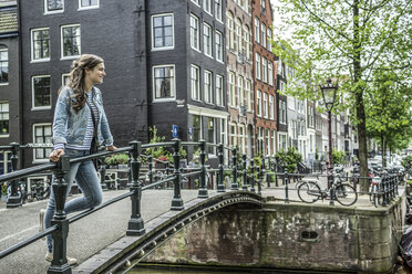 Niederlande, Amsterdam, Touristin auf Fußgängerbrücke stehend - RIBF000075