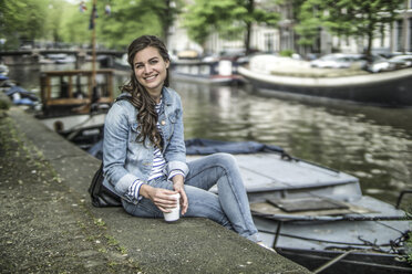Netherlands, Amsterdam, portrait of female tourist having a rest - RIBF000086