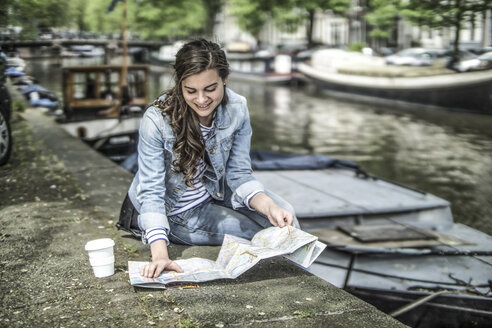 Niederlande, Amsterdam, weibliche Touristin beim Ausruhen mit Blick auf den Stadtplan - RIBF000087