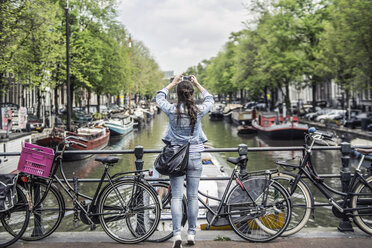 Niederlande, Amsterdam, weibliche Touristin macht ein Selfie mit Smartphone - RIBF000089