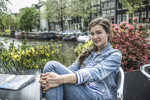 Niederlande, Amsterdam, Porträt einer Touristin, die sich in einem Straßencafé ausruht - RIBF000104