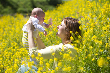 Mutter mit ihrem kleinen Mädchen auf einem gelb blühenden Blumenfeld - WWF003899