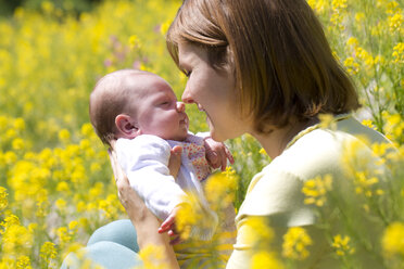 Mutter mit ihrem kleinen Mädchen auf einem gelb blühenden Blumenfeld - WWF003900