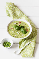 Soup dish of pea soup with radishes garnished with basil leaves - EVGF001870