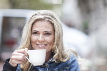 Porträt einer lächelnden Frau beim Kaffeetrinken - ZEF006569