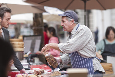 Man selling sausage at city market - ZEF006576