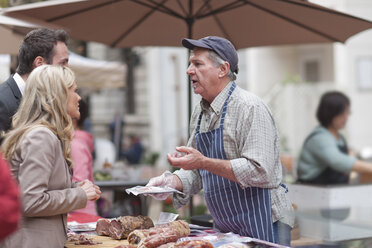 Man selling sausage at city market - ZEF006577