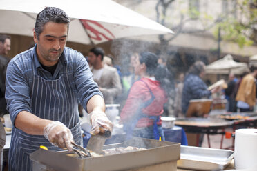 Mann beim Grillen von Fleisch auf dem Stadtmarkt - ZEF007018