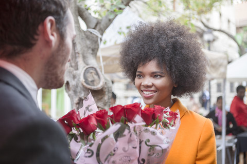 Mann kauft rote Rosen für eine Frau, lizenzfreies Stockfoto