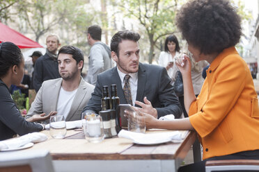 Colleagues with digital tablet at outdoor restaurant - ZEF007025