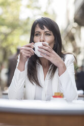Frau trinkt Kaffee in einem Straßencafé - ZEF006590