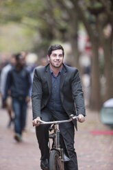Mann fährt Fahrrad in einer Stadt - ZEF007054