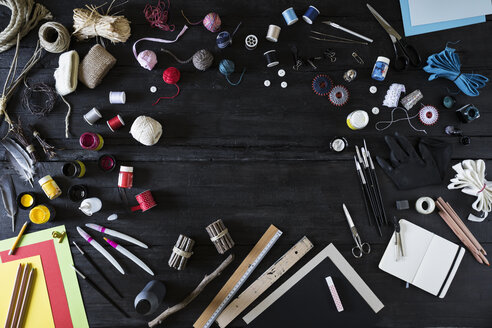 Arrangement of craft materials and tools on black wood - PDF000955