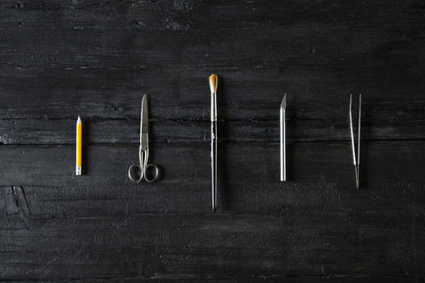 Row of different tools on black wood stock photo