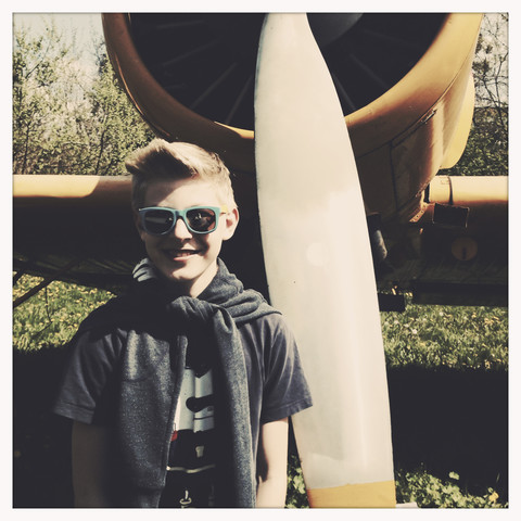 Kleiner Junge mit Sonnenbrille vor einem Propellerblatt, klassisches Flugzeug, Dessau, Deutschland, lizenzfreies Stockfoto