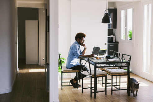 Young man working with laptop at home office - EBSF000657