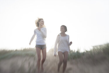 Zwei Freundinnen laufen auf einer Stranddüne - ZEF005286