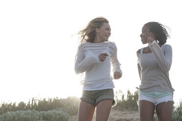 Two female friends running on a beach dune - ZEF005287