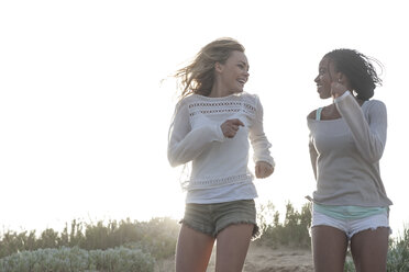 Zwei Freundinnen laufen auf einer Stranddüne - ZEF005287