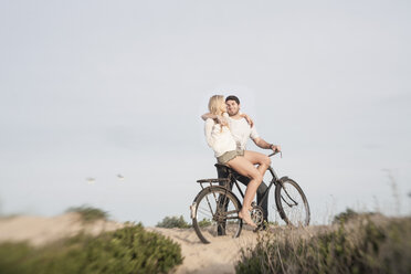 Junges Paar mit Fahrrad auf einer Stranddüne stehend - ZEF005288